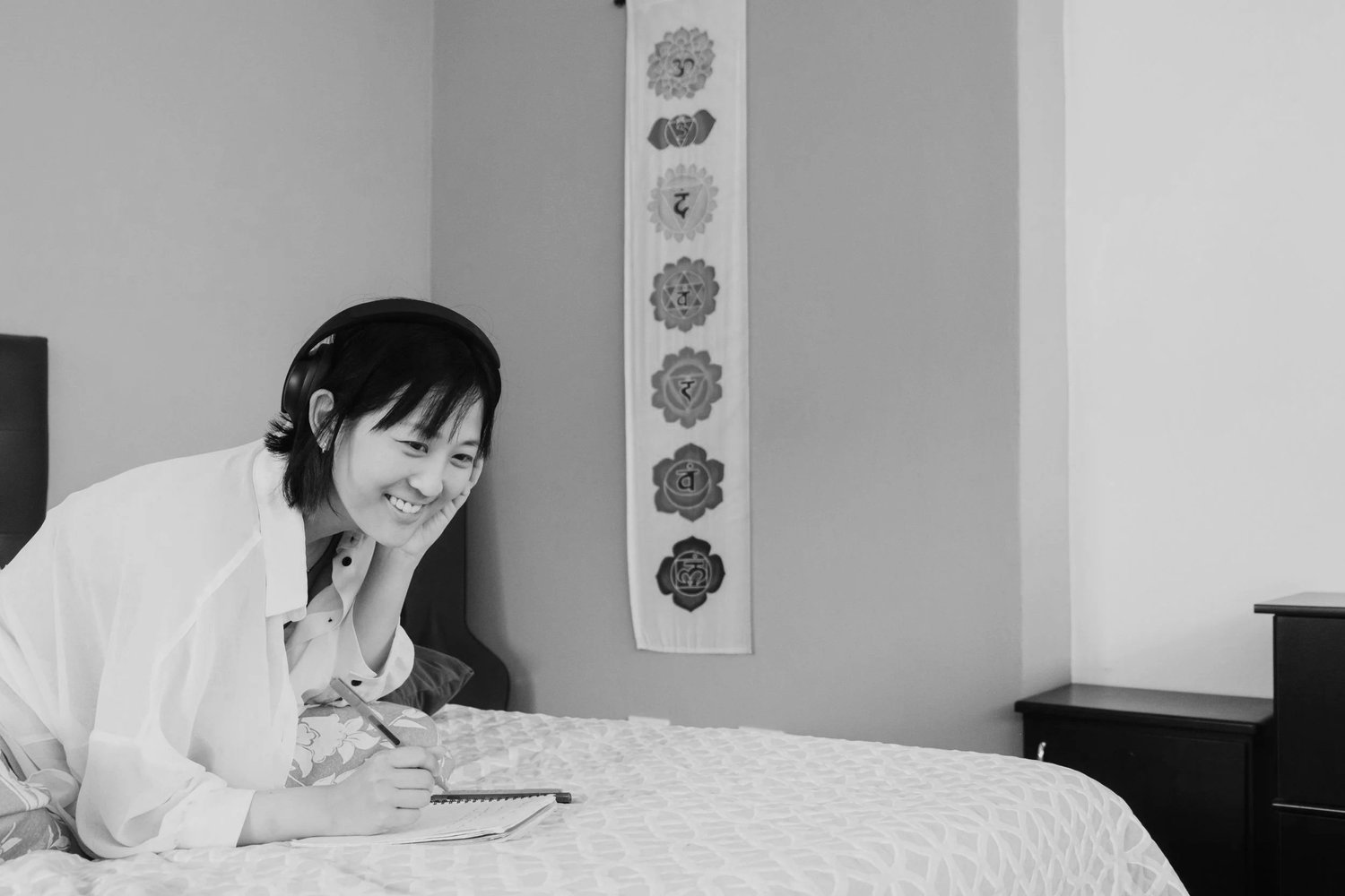 A woman at home with headphones, journaling, at ease